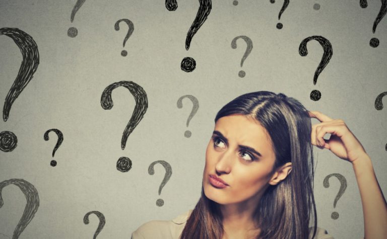 confused thinking woman scratching her head looking up at many question marks